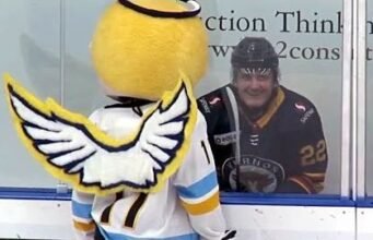 O mascote anjo do time júnior de hóquei canadense encara o jogador em ‘sua lixeira’