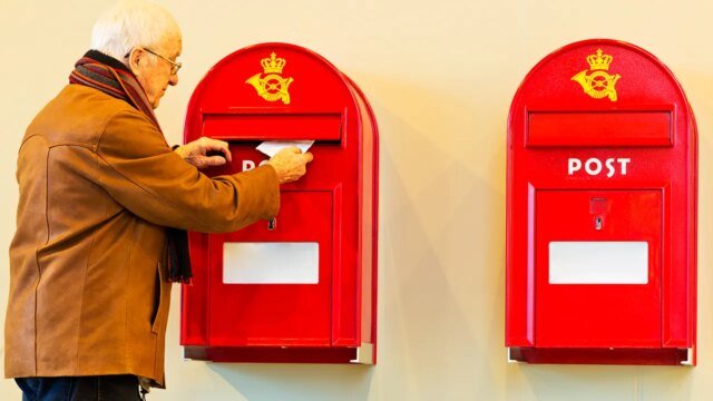 elderly-man-puts-letter-in-danish-mailbox.jpg