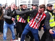 Torcedores do Sunderland são vistos segurando a cabeça após serem atingidos por garrafas atiradas por torcedores do Newcastle enquanto torcedores se enfrentam antes do dia do derby