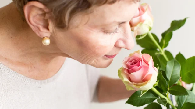 senior-woman-smelling-pink-rose.webp.webp